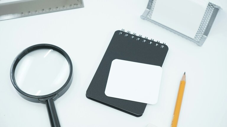 A black magnifying glass on white paper