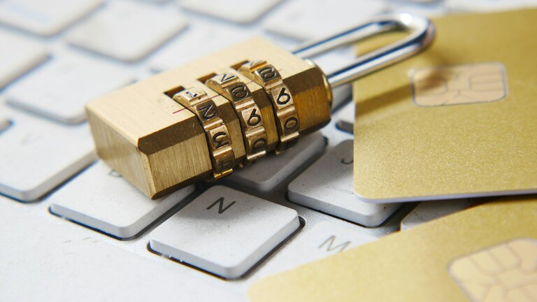 A golden padlock sitting on top of a keyboard